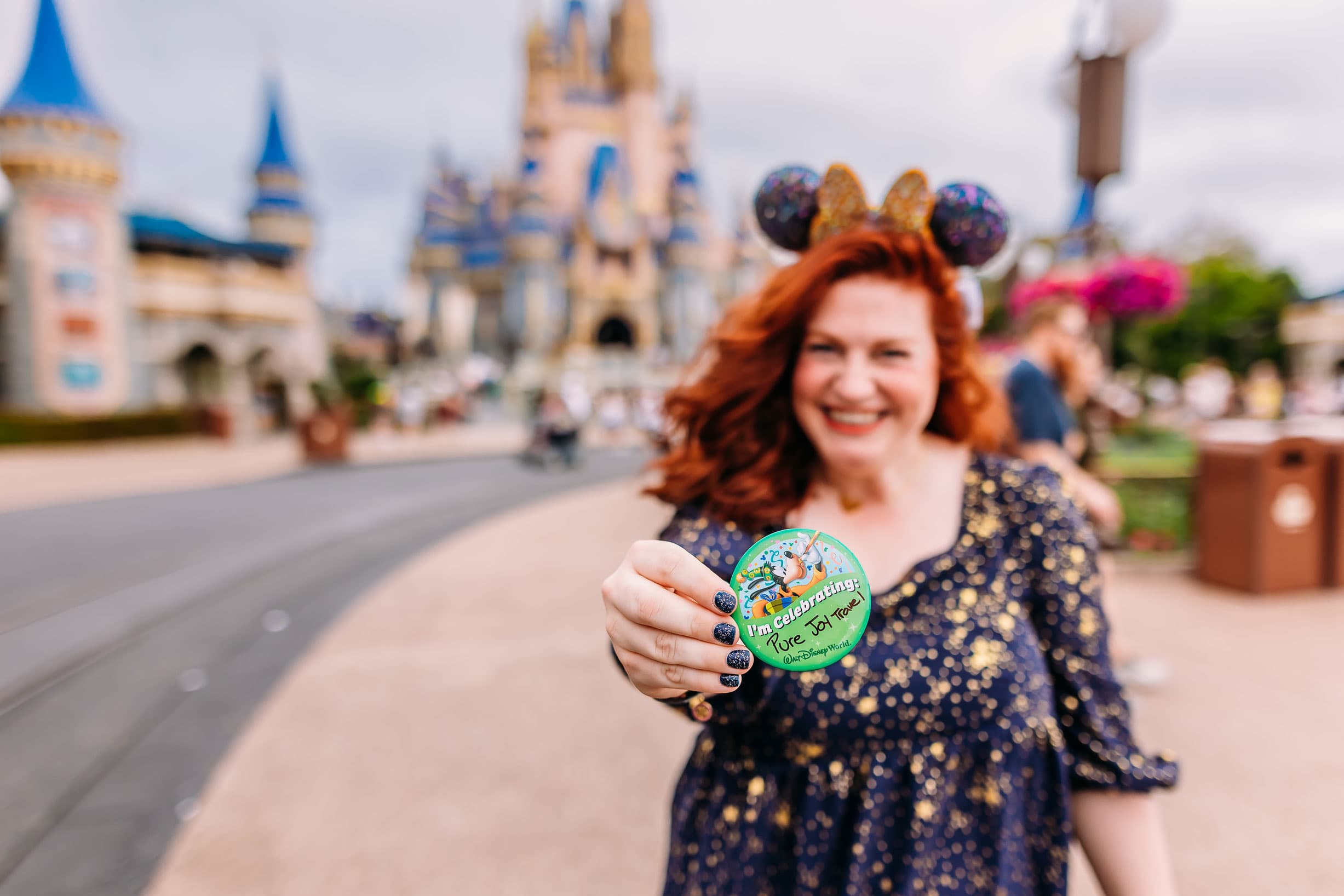 Caitlyn holding a pin in Disneyworld